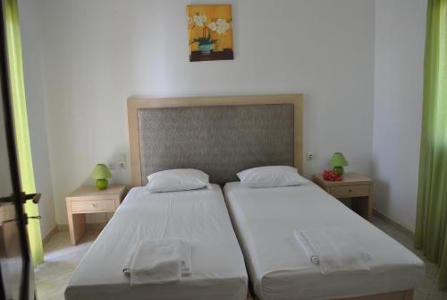 a bedroom with two beds and two night stands at Antigoni Apartments 'Olive Room' in Milatos