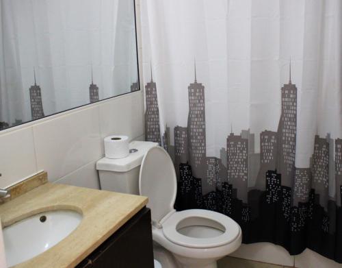 a bathroom with a toilet and a city sticker on the wall at Condominio Vista Azapa Piso 2 Dto 24 in Arica