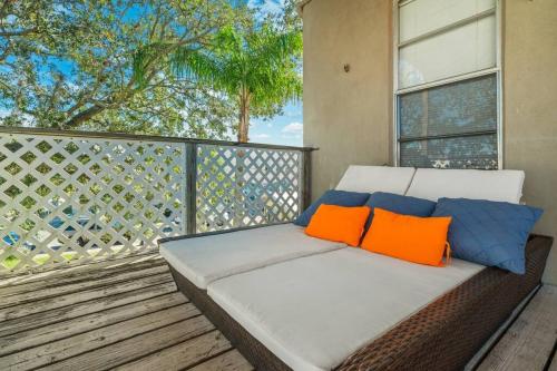 a couch on a balcony with orange and blue pillows at On Sebring CirclePrivate studio apartmentw/balcony in Sebring