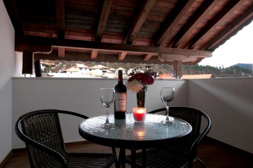 茲拉托格勒的住宿－Бялата Къща 2，一张桌子,上面放着一瓶葡萄酒和两杯酒