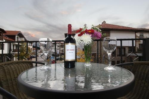 a table with a bottle of wine and two wine glasses at Бялата Къща 2 in Zlatograd