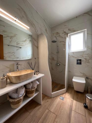 a bathroom with a sink and a shower at Katerina Apartments & Studios in Naousa