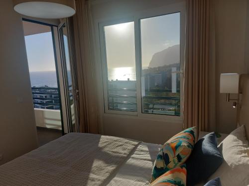 una camera con un letto e una grande finestra di Horizon Dream a Funchal