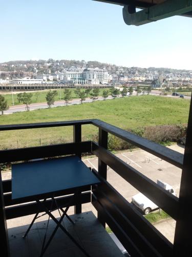 a table on a balcony with a view of a field at Le Arty in Deauville