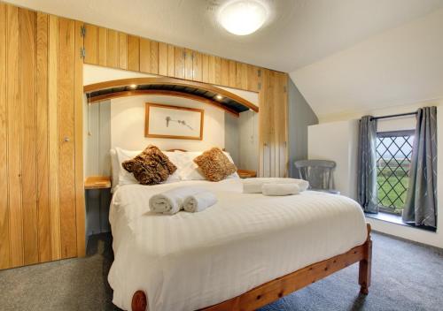a bedroom with a large bed with towels on it at Hafan Penrhyn in St. Davids