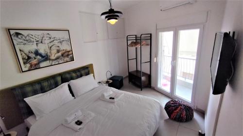 um quarto com uma grande cama branca e uma janela em Zennova #9 City Center Pearl em Tessalônica