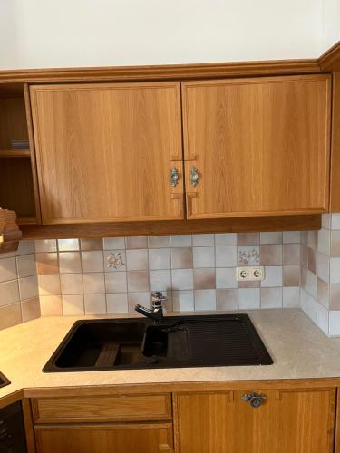 a kitchen with a sink and wooden cabinets at Ferienwohnung Seidl Wohnung Violine in Mittenwald