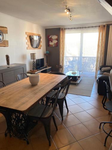 - une salle à manger et un salon avec une table et des chaises en bois dans l'établissement Logement idéal pour un séjour alsacien en amoureux, à Colmar
