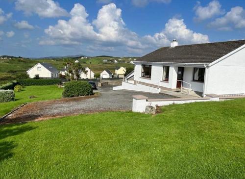 una casa blanca con un patio y una casa en Heather Hill Cottage en Downings