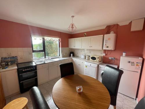 a kitchen with a wooden table and a table and chairs at Heather Hill Cottage in Downings