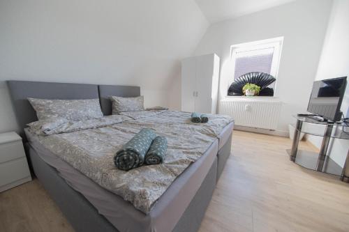 a bedroom with a large bed with shoes on it at KobyApartment in Herford