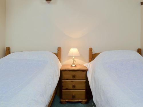 a bedroom with two beds and a lamp on a night stand at Stable Cottage 8 - Ukc3747 in Bawdeswell