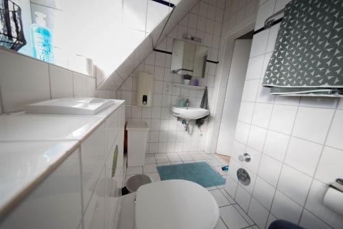 a white bathroom with a toilet and a sink at KobyApartment in Herford