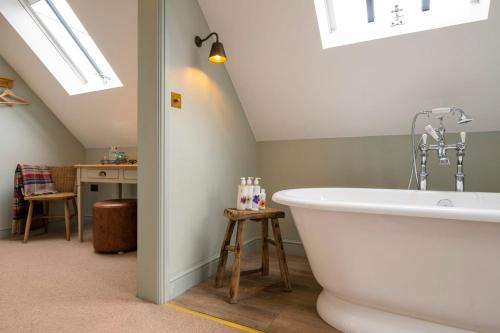 a bathroom with a white bath tub in a attic at The Bottle & Glass Inn - Deluxe Room - Room 3 in Henley on Thames