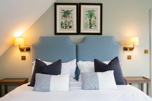 um quarto com uma cama com duas fotografias na parede em The Bottle & Glass Inn - Deluxe Room - Room 3 em Henley on Thames