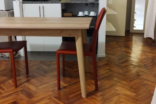 a wooden table with two chairs and a wooden floor at Departamento en Recoleta con Balcon Terraza in Buenos Aires