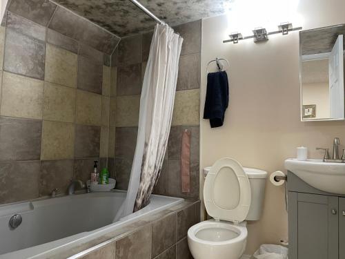 uma casa de banho com uma banheira, um WC e um lavatório. em Super Luxury & Cozy Lower Level Apartment in NW Calgary, AB Close to Banff em Calgary