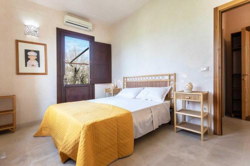a bedroom with a bed with a yellow blanket and a window at Agriturismo De Lorenzi in Casarano