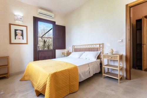 - une chambre avec un lit doté d'une couverture jaune et d'une fenêtre dans l'établissement Agriturismo De Lorenzi, à Casarano