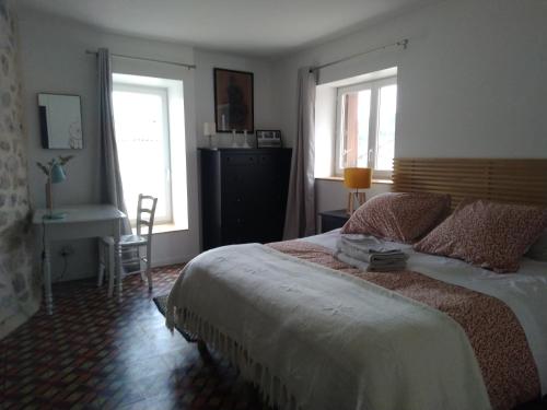 埃雷皮揚的住宿－La Tour de l'Ange，一间卧室设有一张大床和两个窗户。