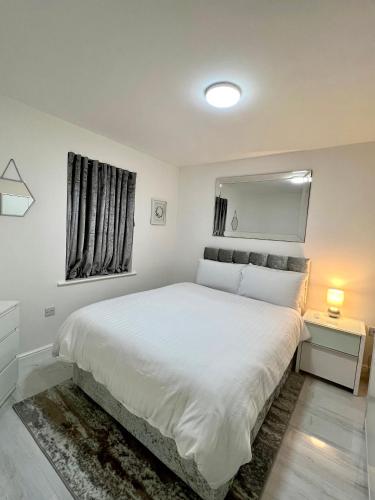 1 dormitorio con 1 cama blanca grande y ventana en RoyalLodge en Londres