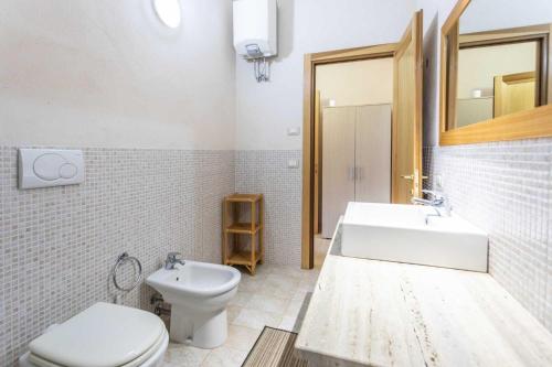 a white bathroom with a toilet and a sink at Agriturismo De Lorenzi in Casarano