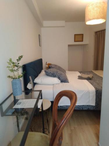 - une chambre avec un lit, une table en verre et une chaise dans l'établissement La Tour de l'Ange, à Hérépian