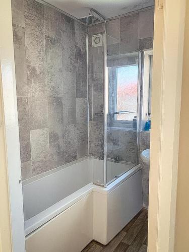 a bathroom with a shower and a tub and a sink at Spacious 7 bed, Contractor Accommodation Stockton on tees in Stockton-on-Tees