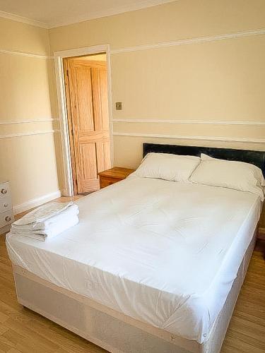 a large bed in a bedroom with a wooden floor at Spacious 7 bed, Contractor Accommodation Stockton on tees in Stockton-on-Tees