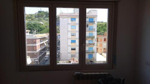 two windows in a room with a view of a building at Appartement Spadafora - 50m de la plage in Spadafora