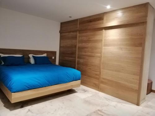 a bedroom with a bed and a wooden wall at Faro Villa in Centre de Flacq