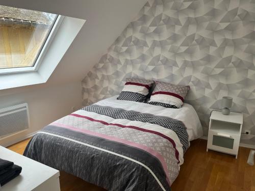 a bedroom with a bed with a geometric wall at Coeur de bouchon in Troyes