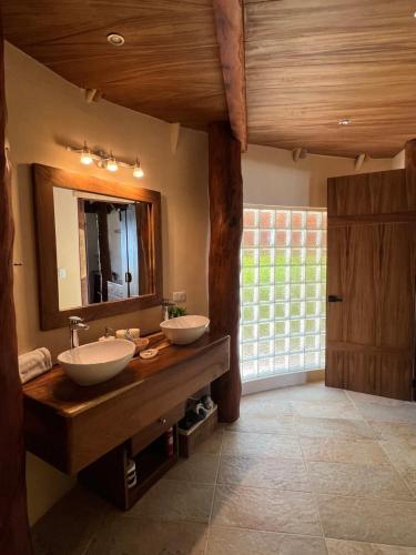 baño con 2 lavabos y espejo grande en El Paraiso Hotel Tulum, en Tulum