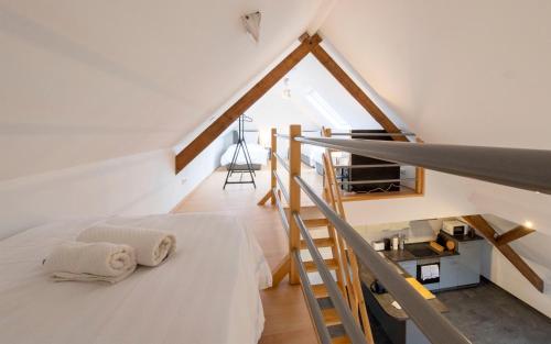 Dormitorio en el ático con cama y escalera en Stay and Work Apartment - 8 single beds - Garage en Hau