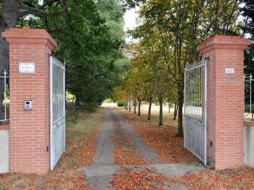 un portail sur une route avec des feuilles au sol dans l'établissement Roulotte Un temps pour soi, à Bérat