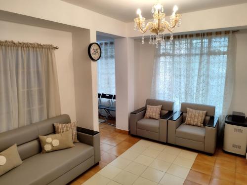 a living room with two couches and a chandelier at Lorin BnB in Kohīma