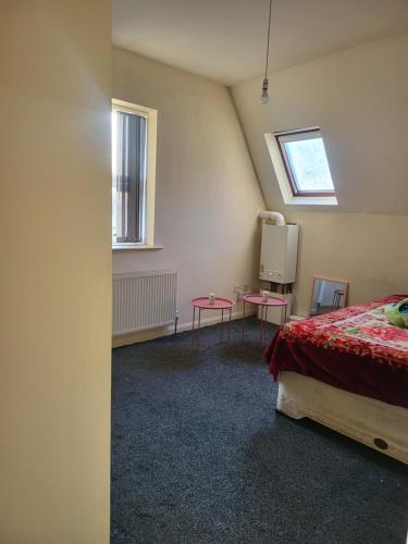 a room with a bed and two tables in it at Cozzy 2 roooms with 2 beds in Bradford