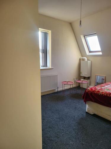 een kamer met een bed, 2 tafels en een raam bij Cozzy 2 roooms with 2 beds in Bradford