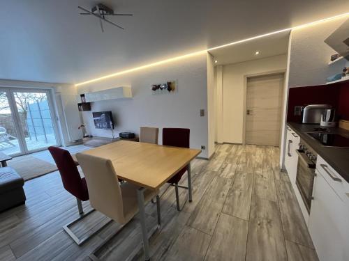 a kitchen and living room with a wooden table and chairs at 90 m2 Appartment with 2 Bedrooms, terrace and garden in Bad Friedrichshall