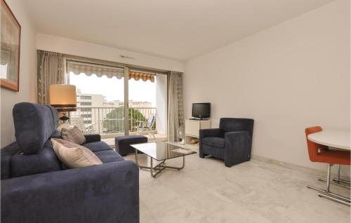 un salon avec un canapé, deux chaises et une table dans l'établissement 1 Bedroom Lovely Apartment In Cannes, à Cannes