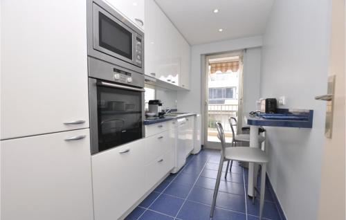 - une cuisine avec des appareils blancs et du carrelage bleu dans l'établissement 1 Bedroom Lovely Apartment In Cannes, à Cannes