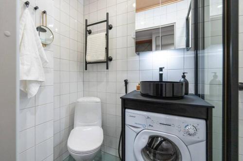 uma casa de banho com uma máquina de lavar roupa e um WC em Luxury Getaway - One-Bedroom Suite w Fireplace em Helsinque