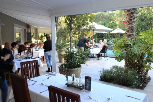 a group of people sitting at tables in a restaurant at Cinnamon Boutique Guest House in Wilderness