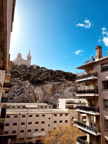 una cometa está volando en el cielo sobre edificios en Notre dame de la garde / Vauban 2 pièces en Marsella