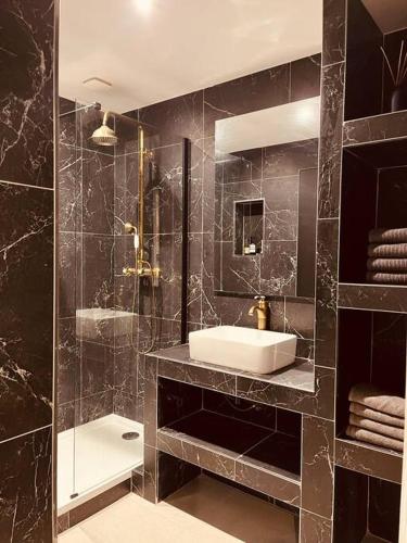 czarna łazienka z umywalką i prysznicem w obiekcie Notre dame de la garde / Vauban 2 pièces w Marsylii