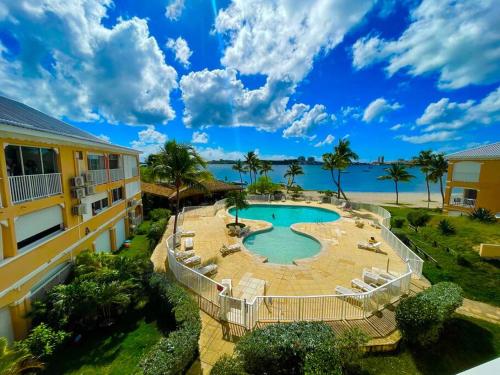 un complexe avec une piscine offrant une vue sur l'océan dans l'établissement Superbe studio lumineux, vue sur piscine et mer, à Baie Nettlé