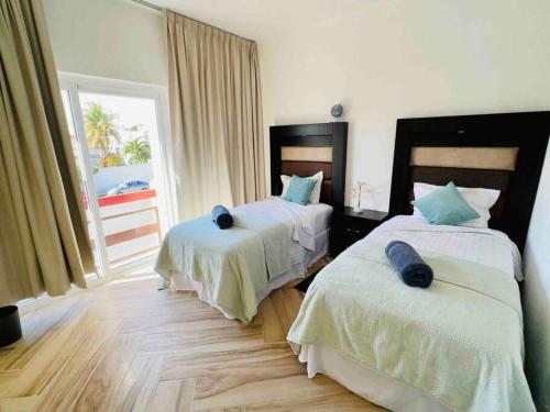 a bedroom with two beds and a window with a view at Casa Copan in Cancún