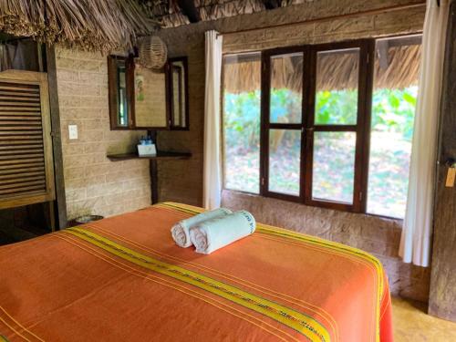 a bed in a room with two rolled towels on it at Hotel Maya Bell in Palenque