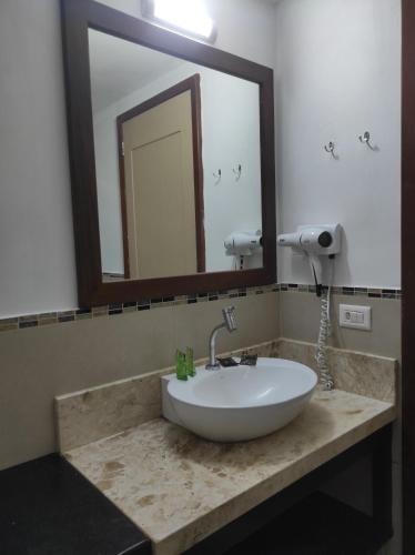 a bathroom with a sink with a mirror and a mirror at Hotel Sao Francisco in Jericoacoara