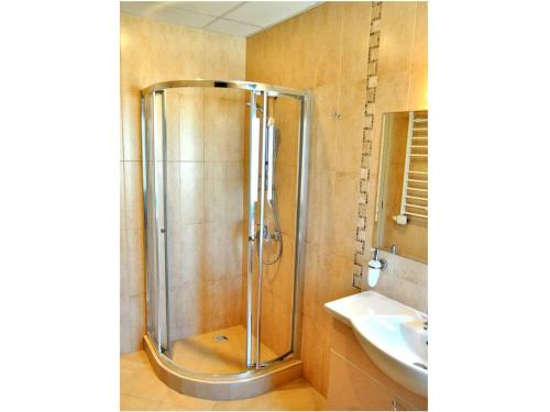 a shower stall in a bathroom with a sink at Yustina Villas Guest House in Ustina